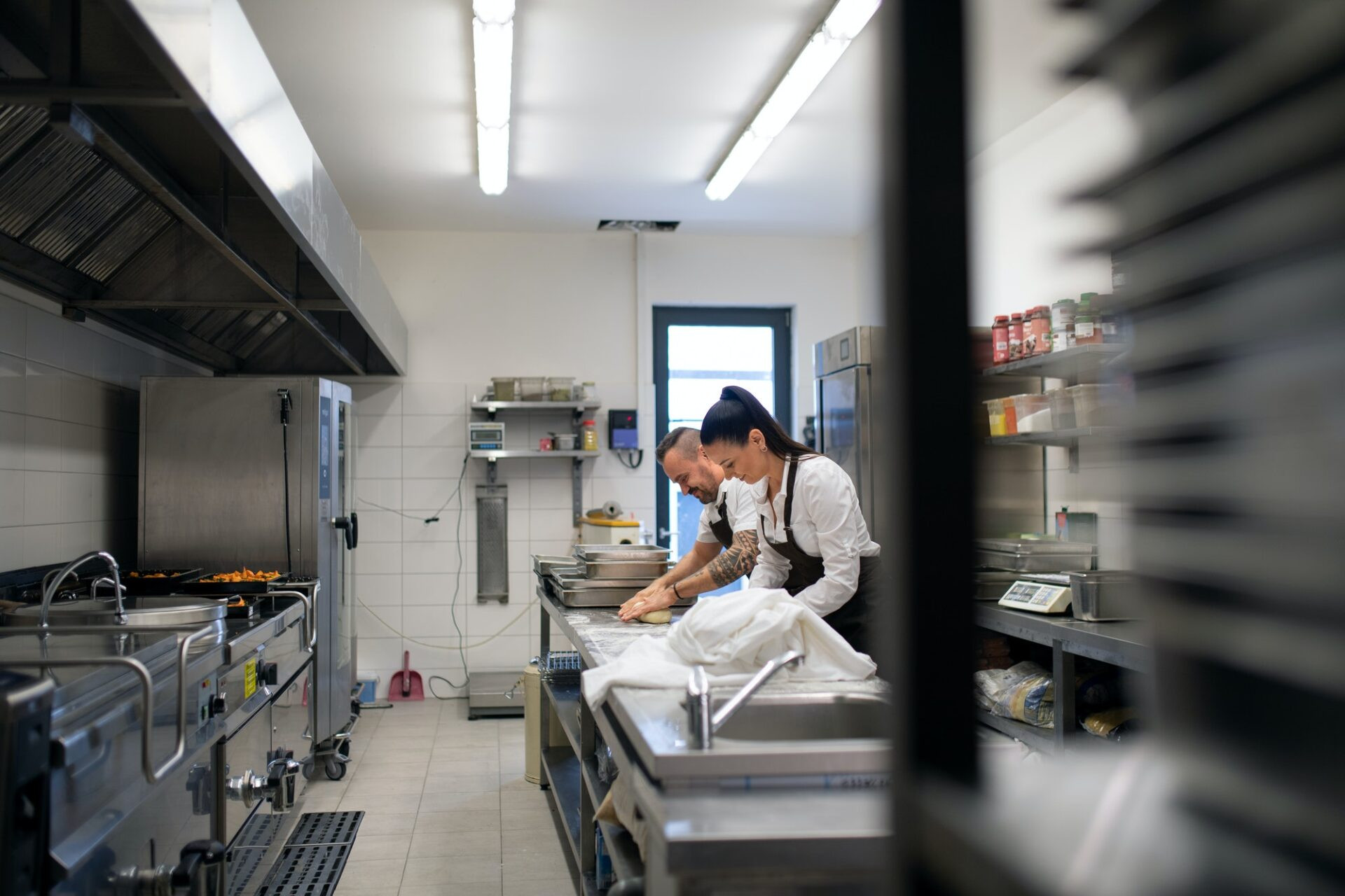 Un chef et un cuisinier travaillant sur leurs plats à l'intérieur dans la cuisine du restaurant.