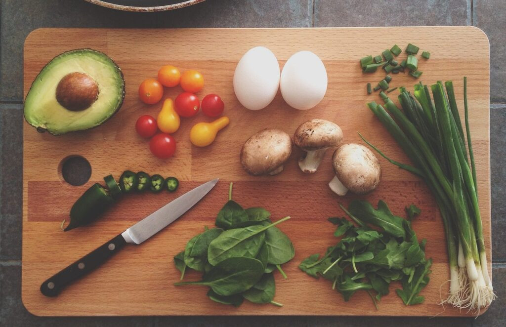 planche de cuisine avec avocat et legumes